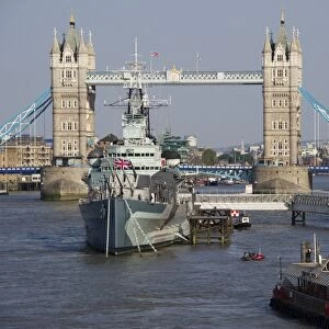 View of HMS Belfast museum ship moored on river in city, Tower Bridge, River Thames, London, England, april