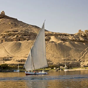 EGYPT, Aswan. The rock-hewn Tombs of the Nobles pock mark the West bank of the Nile