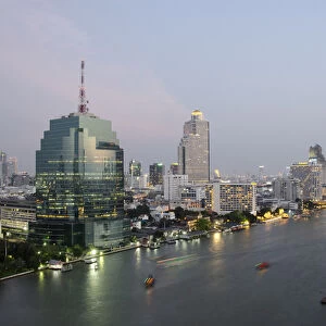 Thailand, Bangkok. Downtown Bangkok, evening skyline view of the Chao Phraya river