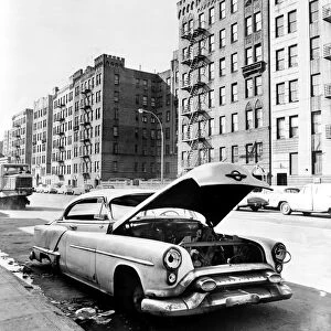 BRONX: ABANDONED CAR, c1964. An abandoned car stripped for parts on Macombs Road in the Bronx