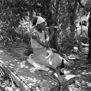 COTTON WORKER, 1937. An African American cotton hoer drinking a bottle of soda