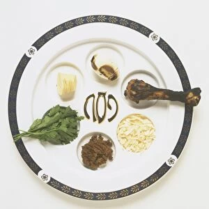 Passover meal or Seder plate, displaying traditional bitter herb, egg, meat leg, charoset, green vegetables