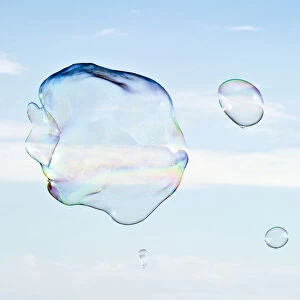 Large soap bubbles in front of a bright blue sky