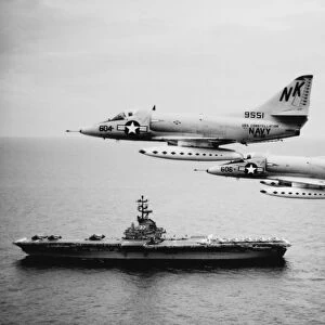 Two A-4C Skyhawk aircraft fly past anti-submarine aircraft carrier USS Kearsarge, 1964