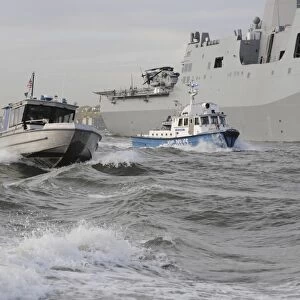 Crews from the coast guard and police departments escort USS New York as it sails