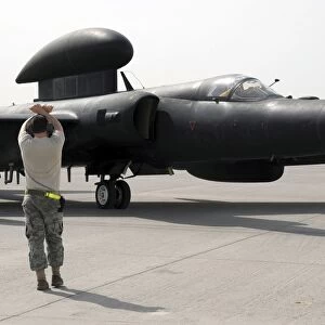 A maintenance Airman guides a pilot in a U-2 Dragon Lady aircraft to a parking space