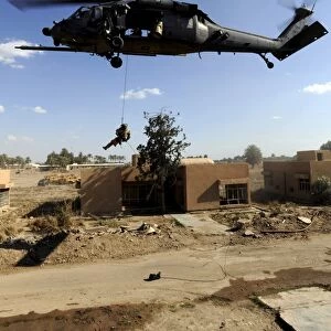 A pararescueman rappels from an HH-60 Pavehawk helicopter