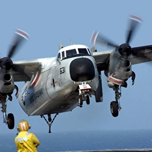 A U. S. Navy officer observes a C-2A Greyhound aircraft landing onboard USS Harry S
