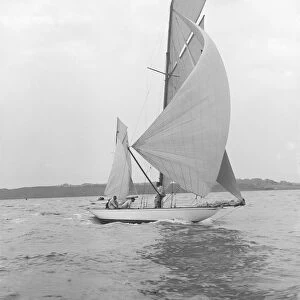 The 8-metre Ierne sailing with spinnaker, 1913. Creator: Kirk & Sons of Cowes