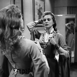 Actress Janet Leigh looks at her reflection in the mirror at a costume fitting for