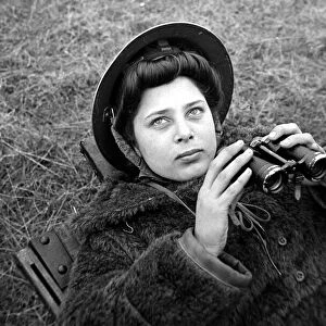 An ATS woman using a pair of binoculars on searchlight Battery January 1943