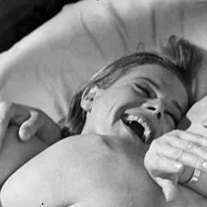 Honor Blackman laughing in bed with Laurence Harvey during filming of Life at the Top