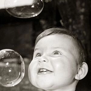 Little boy blowing bubbles, circa 1950