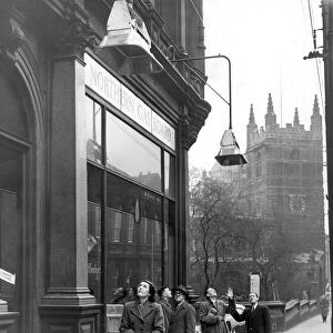 Passers-by looking up at the gas heaters outside the Northern Gas Board showrooms in