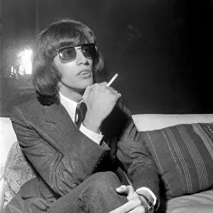 Robin Gibb of the Bee Gees pop group, smoking a cigarette. April 1969