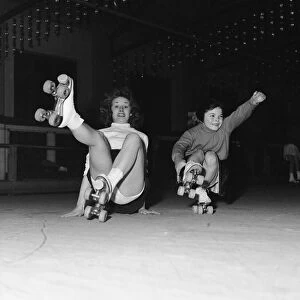 Teenager Betty Jones pictured roller skating with seven year old Anne Morgan at the rink