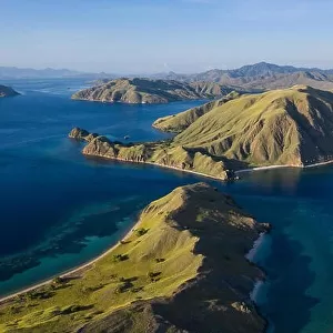 Seen from an aerial view, afternoon light shines on rugged islands in Komodo National Park, Indonesia. This area has high marine biodiversity