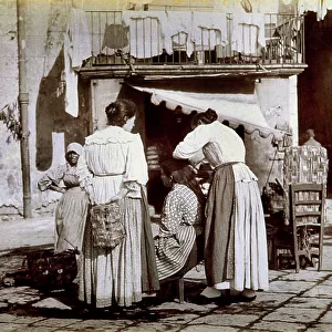 Group of working class women in a street of Naples; one of them is having her hair combed