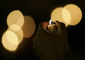 An activist holds a candle during celebrations of the International Day of Peace in