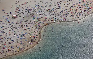 An aerial view shows people at a beach on the shores of lake Silbersee on a hot summer