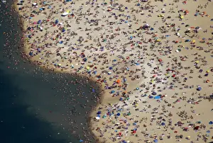 An aerial view shows people at a beach on the shores of the Silbersee lake on a hot