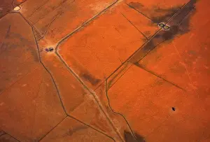 An aerial view of small dams containing water are seen in dry paddocks located north-west