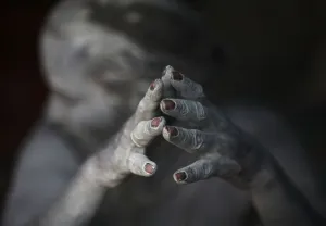 Nepal Prints: Ash-encrusted hands of a sadhu are seen as he sits beside a fire after applying ashes to his face