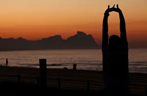 Prints of An athlete stretches in front of Recreio dos Bandeirantes beach before the Rio de Janeiro International Marathon in Rio de Janeiro July 17, 2011 Brazil Prints: An athlete stretches in front of Recreio dos Bandeirantes beach before the Rio de