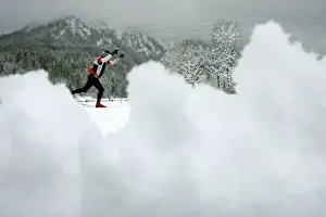 An athlete tries to make his way after heavy snow falls at the cross country race track for