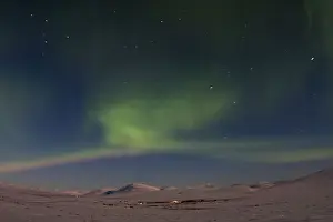 The aurora borealis is seen on Beam Road above snow-covered tundras near Nome, Alaska