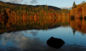 Autumn leaves are reflected on Loch Faskally, Pitlochry, Scotland