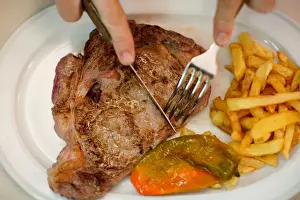A beef steak is cut at the Taberna del Gijon restaurant in Madrid