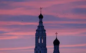 Birds fly over the Annunciation church at dawn in the village of Lipitsy