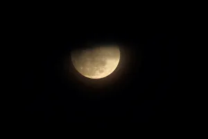 A blue moon rises through clouds in San Diego, California