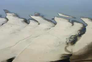 Latin America Prints: A boat moors to a sand bar exposed by the receding waters of the Rio Solimoes river