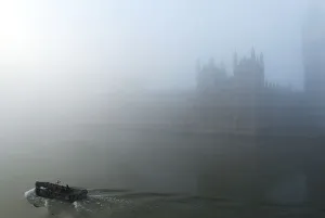 United Kingdom Prints: A boat on the River Thames passes the Houses of Parliament, in heavy fog in central
