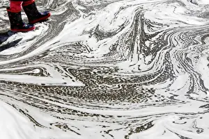 Weather Prints: The boots of a young girl are seen in a puddle caused by melted snow at Madison Square