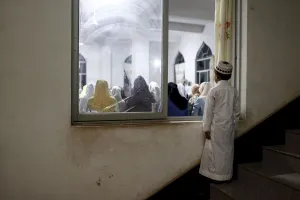 Religion Prints: A boy looks in through a window as he and other worshippers pray on Laylat al-Qadr during