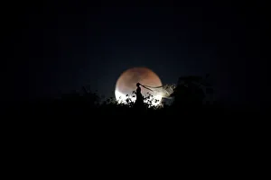 Lunar Prints: A bride poses for photo during a total lunar eclipse from in Brasilia