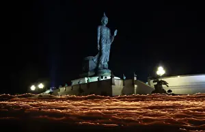 Thailand Prints: Buddhists carry candles while encircling a large Buddha statue during Vesak Day in Nakhon