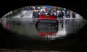 India Prints: A bus is seen submerged on a flooded road under a railway bridge after heavy rains in New