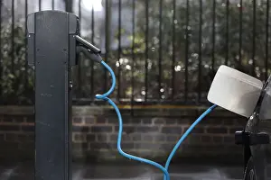 Ev Prints: A car is plugged in at a charging point for electric vehicles in London