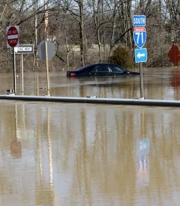 A car is submerged in water that covers the off ramp of interstate 71 along the Ohio A car is submerged in water that covers the off ramp of interstate 71 along the Ohio
