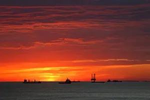 : Cargo ships and an offshore supply vessel lie at anchor at sunrise off Sousse