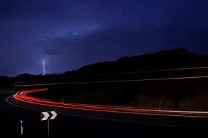 Prints of Cars drive as lightning strikes near the site where a group of Israeli youths was swept away by a flash flood, near the Zafit river bed, south to the Dead Sea, Israel, April 26, 2018 Israel Prints: Cars drive as lightning strikes near the site where a group of Israeli youths was swept