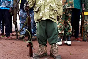 A former child soldier holds a gun as they participate in a child soldiers release ceremony