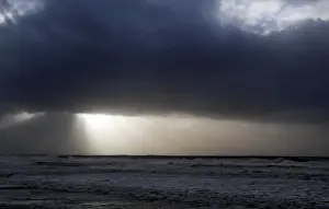 Clouds are pictured as waves break along Frances Atlantic coastline at sunset in Lacanau