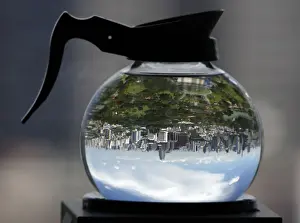 A coffee pot filled with water acts as a lens to depict Lumpini Park in Bangkok