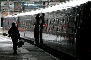 Commuter walks to board a train at Kings Cross station in central London