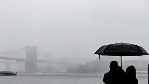 Weather Prints: A couple stops to look at the Brooklyn Bridge during a winter nor easter storm in New